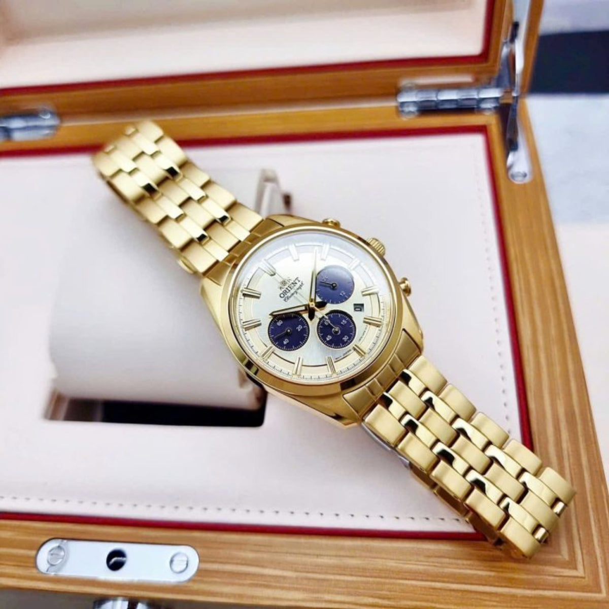 Gold solar chronograph watch on steel bracelet, champagne dial with blue subdials.