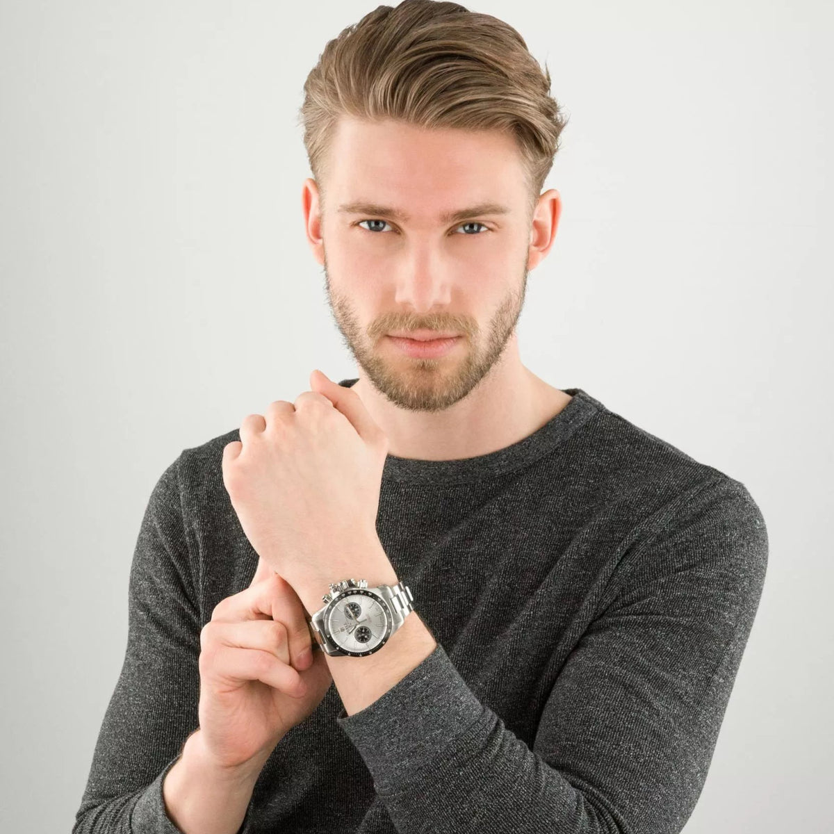 Man wearing a stainless steel chronograph automatic watch with white dial and subdials